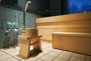 a bathroom with a shower with a bench and a sink at Sanyoan in Otofuke