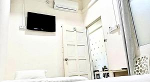 um quarto com uma cama, um espelho e uma televisão em Ozzy Lodge Semporna em Semporna