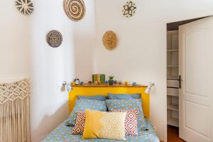 a bedroom with a bed with blue and yellow pillows at La Vie de Bohème Avignon in Avignon