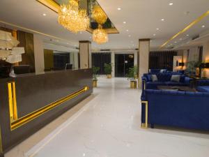 a lobby with blue furniture and chandeliers at Envoy Continental Hotel in Islamabad