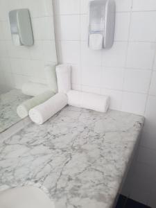 Baño blanco con encimera de mármol en Aquamarine Hotel en Eilat