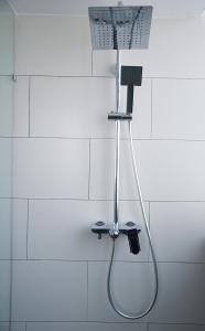a shower in a white tiled bathroom at G5 HOTEL AND SERVICED APARTMENT in Johor Bahru
