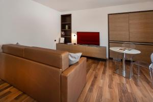 un soggiorno con un divano e un tavolo di APPARTAMENTI CAPRI MALCESINE a Malcesine