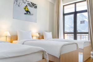 a hotel room with three beds and a window at Rosa Ski Inn Hotel Rosa Khutor in Estosadok