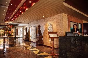 a woman standing at a counter in a lobby at Hotel Cervantes in Guadalajara