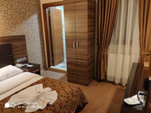 イスタンブールにあるHotel Bazaarのベッド1台とガラスのスライドドアが備わるホテルルームです。