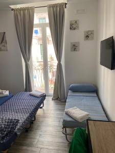 2 Betten in einem Zimmer mit Fenster in der Unterkunft Room27 in Taranto
