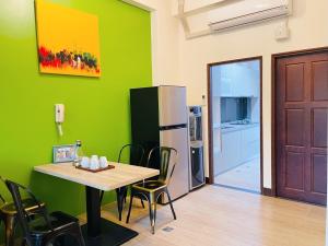 a dining room with a table and a refrigerator at 時光旅舍新館 in Jinning