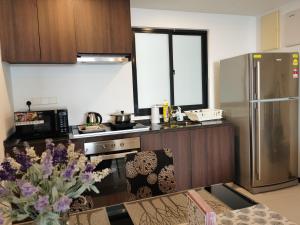 a kitchen with a stainless steel refrigerator and a table at Landmark Lovely Coast View King Suite#500mbpsWifi#Netflix in Tanjong Tokong