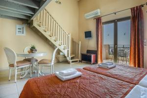 a bedroom with a bed and a table and stairs at Crystal Palace - Vista in Skala Kefalonias