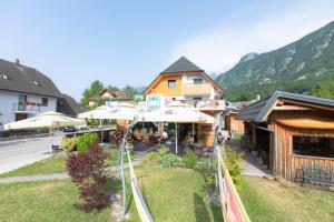 an outdoor restaurant with umbrellas in front of a building at Hostel Soča Rocks in Bovec