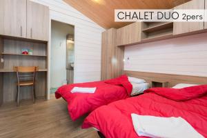two beds in a room with red sheets at Chateau De La Plinguetiere in Saint-Aignan-Grand-Lieu