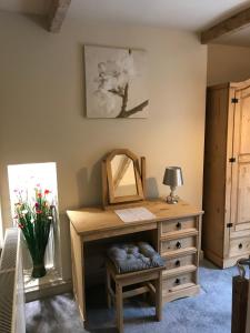 a dressing room with a dresser and a mirror at Bridge Cottage in Cowling