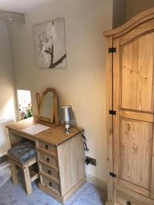 a wooden desk with a lamp and a wooden door at Bridge Cottage in Cowling