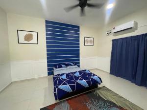 Habitación con una pared azul y una cama en No 61 Nazirin Homestay Tmn Indah Raya 2 Manjung Lumut, en Lumut
