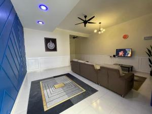 ルムットにあるNo 61 Nazirin Homestay Tmn Indah Raya 2 Manjung Lumutのソファと天井ファン付きの待合室