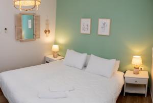 1 dormitorio con 1 cama blanca y 2 mesitas de noche en אבנון - אירוח מדברי, en Yeruham