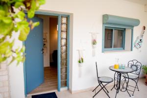 Habitación con puerta azul, mesa y sillas en אבנון - אירוח מדברי en Yeruham