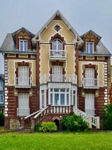ein großes Backsteinhaus mit Treppen drauf in der Unterkunft La Madelon Front de mer in Villers-sur-Mer