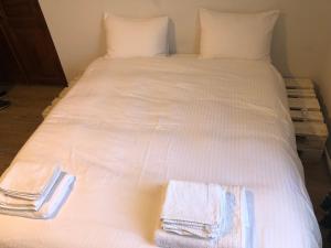 a white bed with two towels on it at Ethno House inn Tianeti in Tʼianetʼi