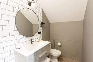 a white bathroom with a sink and a mirror at Don Major in Rostov on Don