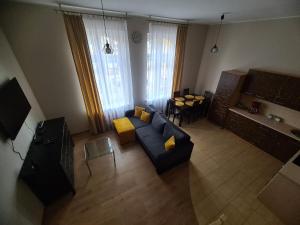 ApartamentyPrzyMorzu Apartament z Antresolą في كولوبرزيغ: غرفة معيشة مع أريكة زرقاء وطاولة