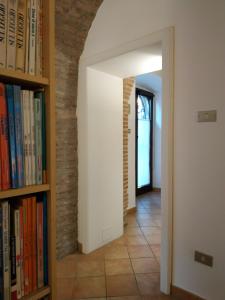 a hallway with bookshelves and a brick wall at Bed and Breakfast In Piazza Orazio in Venosa