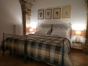 una camera con un letto con due lampade e due quadri appesi al muro di Bed and Breakfast In Piazza Orazio a Venosa