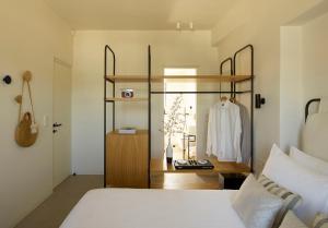 a bedroom with a bed and a shelf with a robe at Chill & Co. Serifos in Livadion