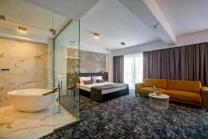 Habitación de hotel con bañera, cama y sofá en Hotel Wiki Sanok Events & Bowling en Sanok