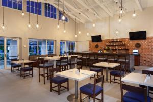 a restaurant with tables and chairs and a bar at Four Points by Sheraton Orlando Convention Center in Orlando