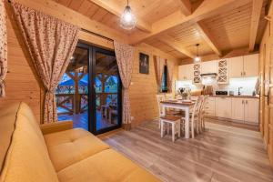 a kitchen and living room in a log cabin at Chaty Skwirutowe Wzgórze - Domki Całoroczne in Solina