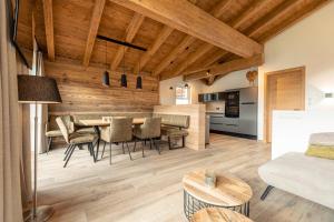eine Küche und ein Wohnzimmer mit einem Tisch und Stühlen in der Unterkunft Tauernlodges Uttendorf by ALPS RESORTS in Uttendorf