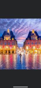 a person with an umbrella in front of two buildings at la cantina in Charleville-Mézières