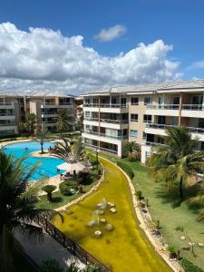 um resort com piscina, palmeiras e edifícios em Apartamento Breezes do Cumbuco - TÉRREO o famoso pé na areia em Cumbuco