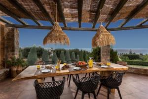a wooden table in a patio with chairs around it at Luxury Villa Golden Crest with private swimming pool in Hersonissos
