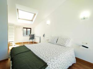 ein weißes Schlafzimmer mit einem Bett und einem Fenster in der Unterkunft Casa BellMón vive el Astroturismo en Belltall in Belltal
