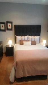 a bedroom with a large bed with two lamps at Cubelas Porto do Son in Porto do Son
