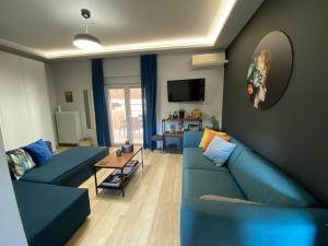 a living room with two blue couches and a table at ASIMINA apartment, Kerameikos Metro Station in Athens