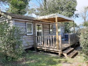 里夫杜海滩Camping 4 étoiles Les Fougères的带门廊和露台的小房子
