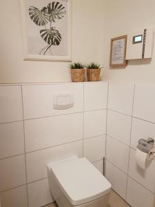ein Bad mit einem WC und einem Bild an der Wand in der Unterkunft Ferienwohnung Quartier HOHE GEEST 12 in Cuxhaven