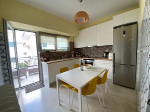 una cucina con tavolo bianco e sedie gialle di ASIMINA apartment, Kerameikos Metro Station ad Atene
