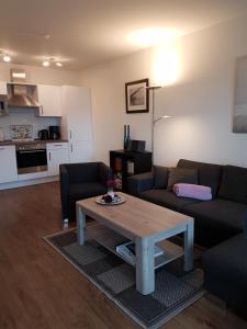 uma sala de estar com um sofá e uma mesa de centro em Ferienwohnung Quartier HOHE GEEST 12 em Cuxhaven
