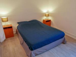 1 dormitorio con 1 cama azul y 2 mesitas de noche en Gîte du Four Banal - gitesdesbalcons-com, en Crémieu