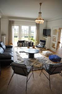 sala de estar con sofás, mesa y sillas en Edville Home, en Gante