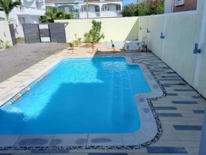a large blue swimming pool in a backyard at Idyllic Villa in Pereybere with Private Pool in Pereybere