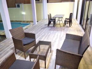 a patio with chairs and tables and a pool at Idyllic Villa in Pereybere with Private Pool in Pereybere