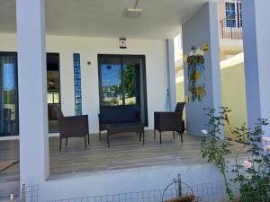 a porch of a house with chairs and tables at Idyllic Villa in Pereybere with Private Pool in Pereybere