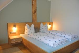 una camera da letto con un letto con due cuscini sopra di Haus Fischer Nassfeldblick a Kirchbach