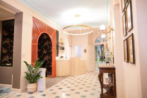 un couloir avec du carrelage et un lustre dans l'établissement Hotel Louison, à Paris